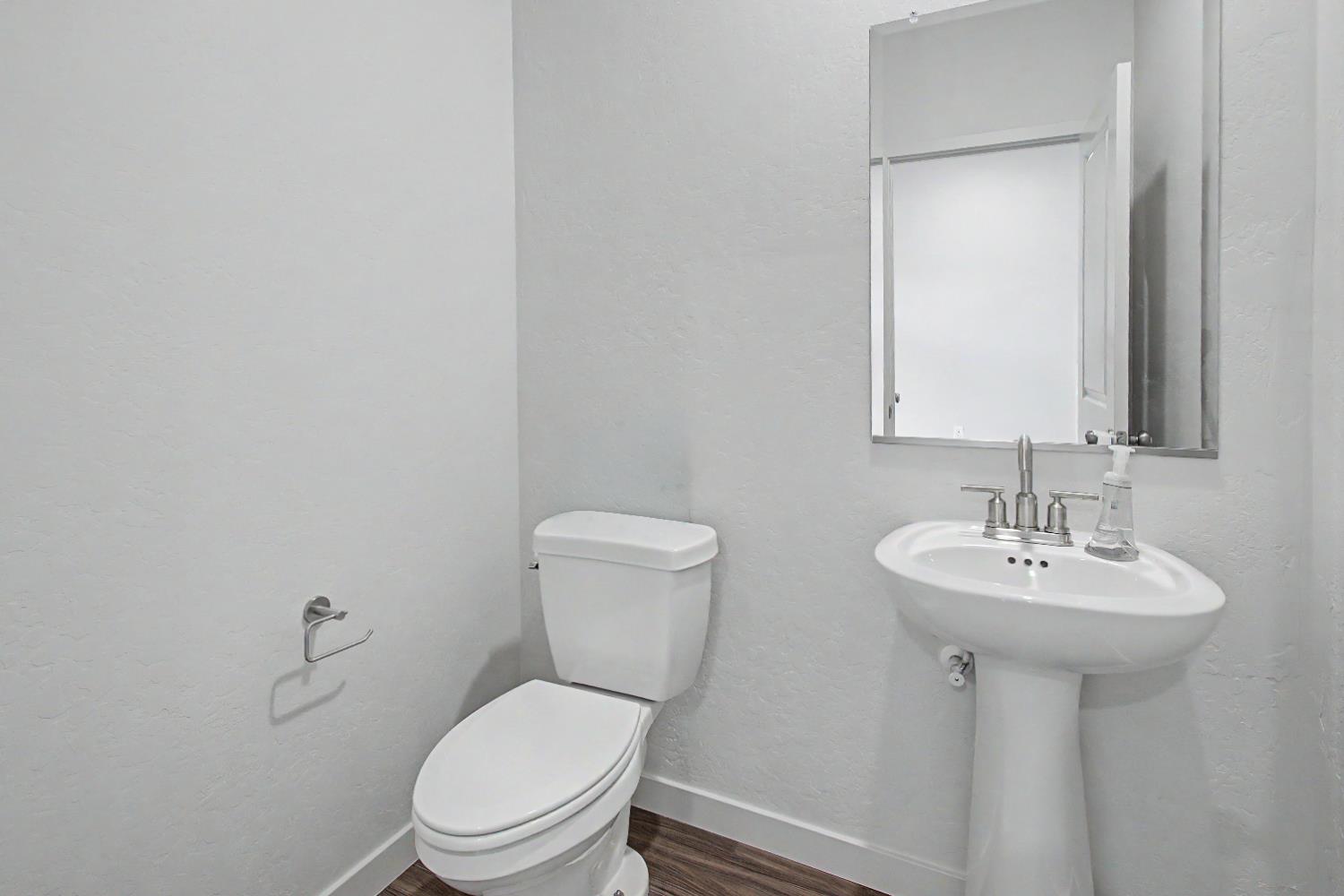 4119 Anise Court Merced, CA 95348 - Photo 8 of 27 a bathroom with a toilet sink and mirror