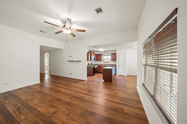 an empty room with wooden floor and windows