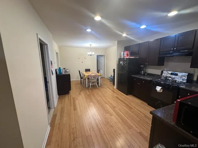 a kitchen with cabinets wooden floor and stainless steel appliances