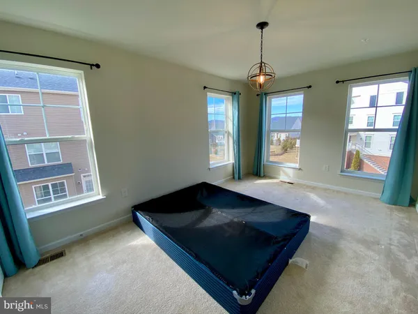 a view of empty room with wooden floor and windows