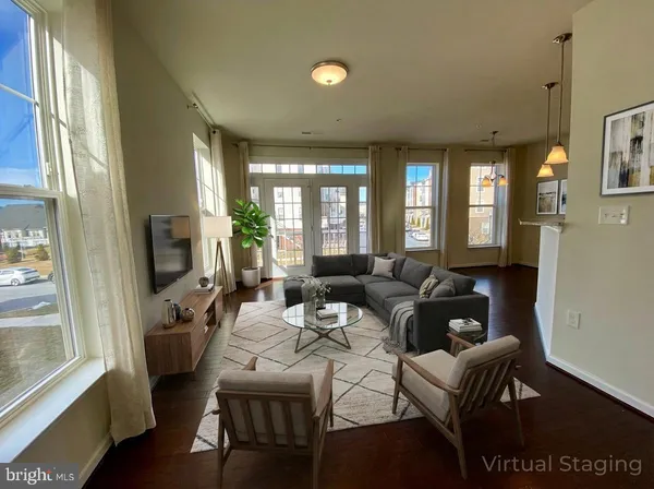 a living room with furniture wooden floor and a large window