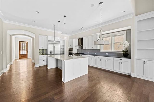 a kitchen with a table a refrigerator and cabinets