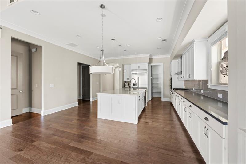 6454 Meridian Way Atlanta, GA 30328 - Photo 14 of 63 a large kitchen with stainless steel appliances a large counter top a sink a refrigerator and a window