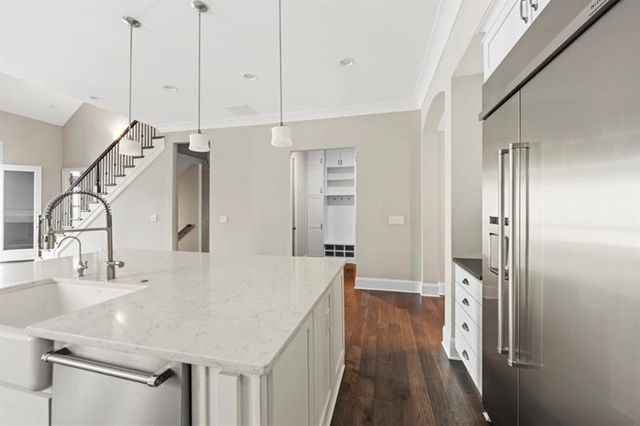 a view of staircase and kitchen with sink wooden floor and windows