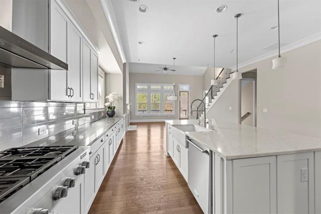 a kitchen that has a lot of cabinets a sink and appliances in it
