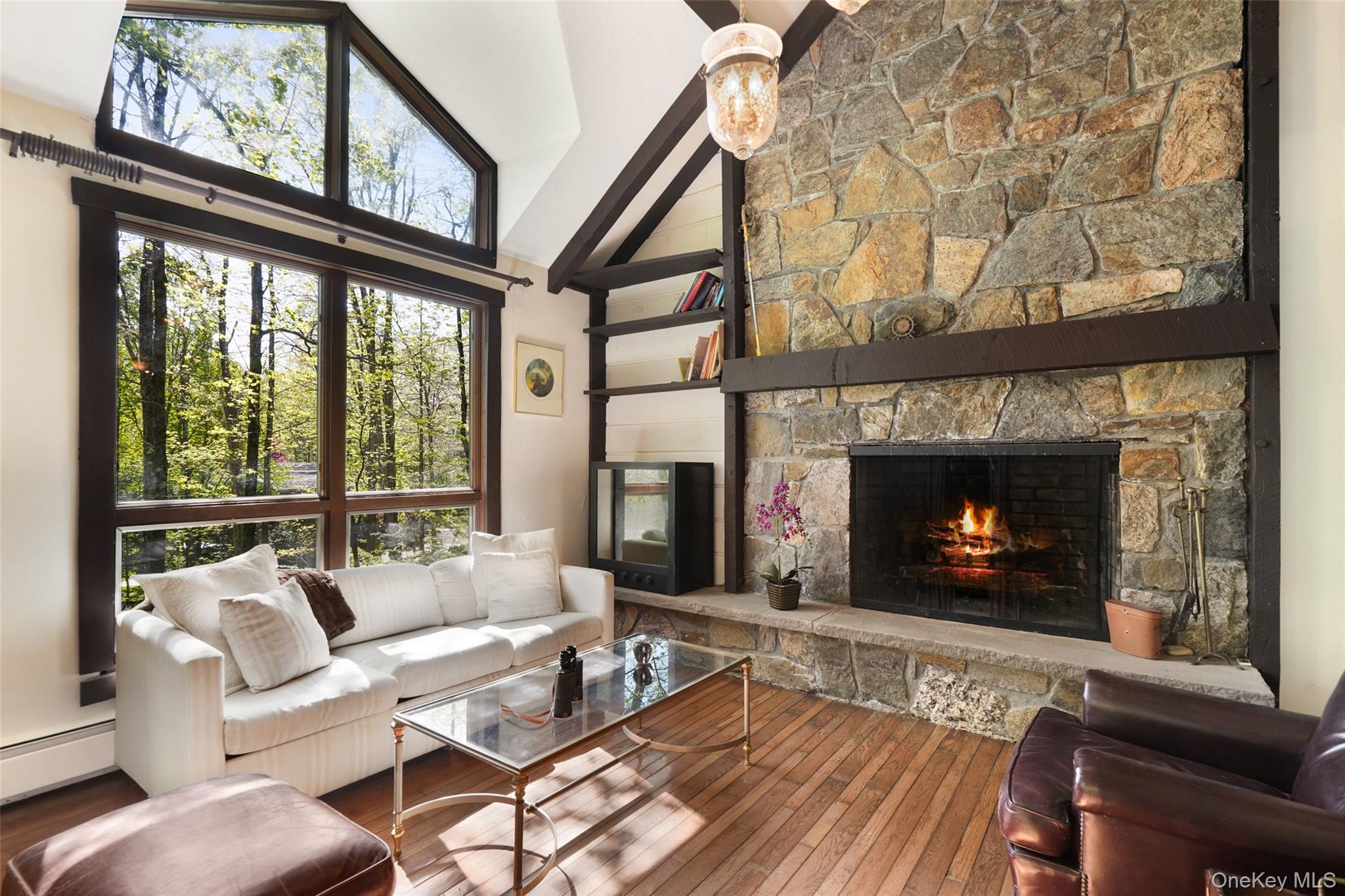 334 Pine Brook Road Pound Ridge, NY 10506 - Photo 6 of 28 a living room with furniture a fireplace and a floor to ceiling window