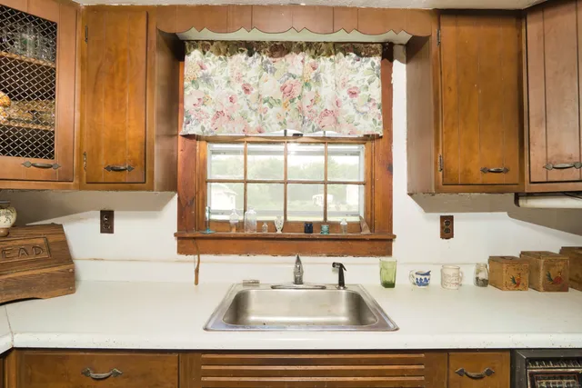 a kitchen with stainless steel appliances a sink a window and cabinets