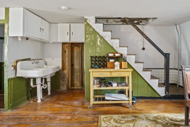 a living room with furniture a large window and stainless steel appliances