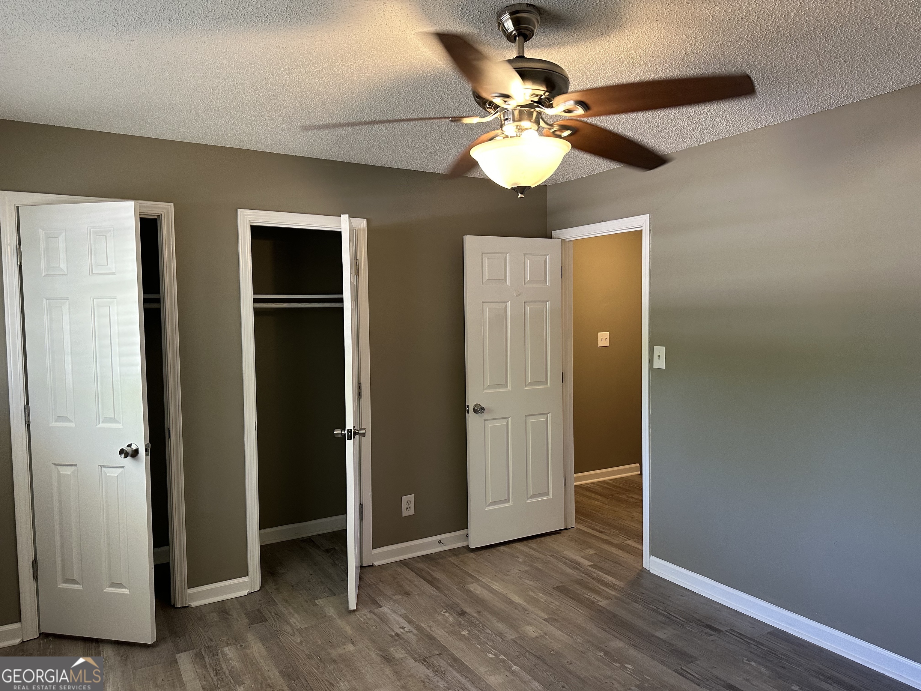205 Maret Street Hartwell, GA 30643 - Photo 16 of 38 an empty room with wooden floor fan and windows