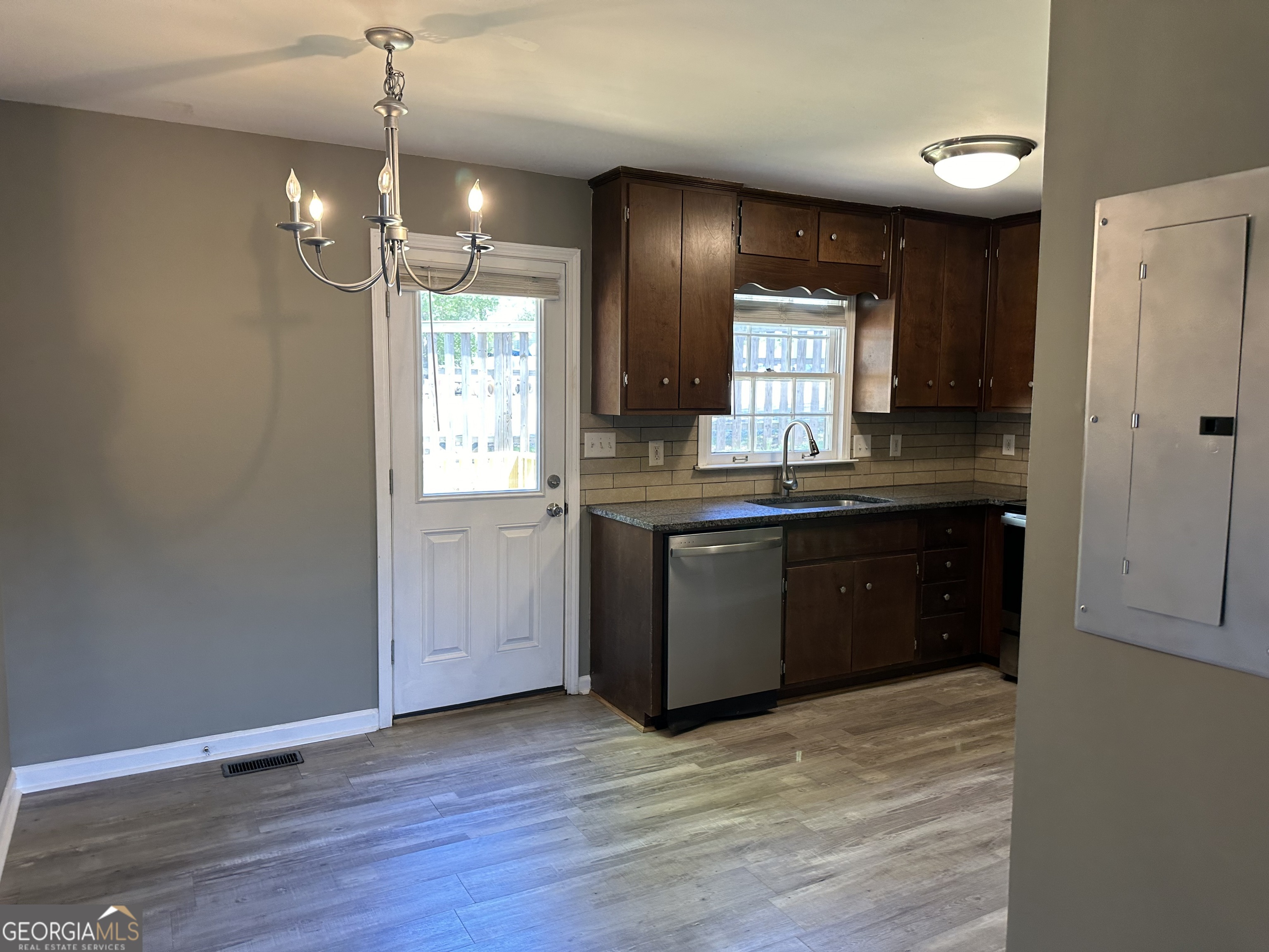 205 Maret Street Hartwell, GA 30643 - Photo 20 of 38 a kitchen with kitchen island granite countertop wooden cabinets and white appliances