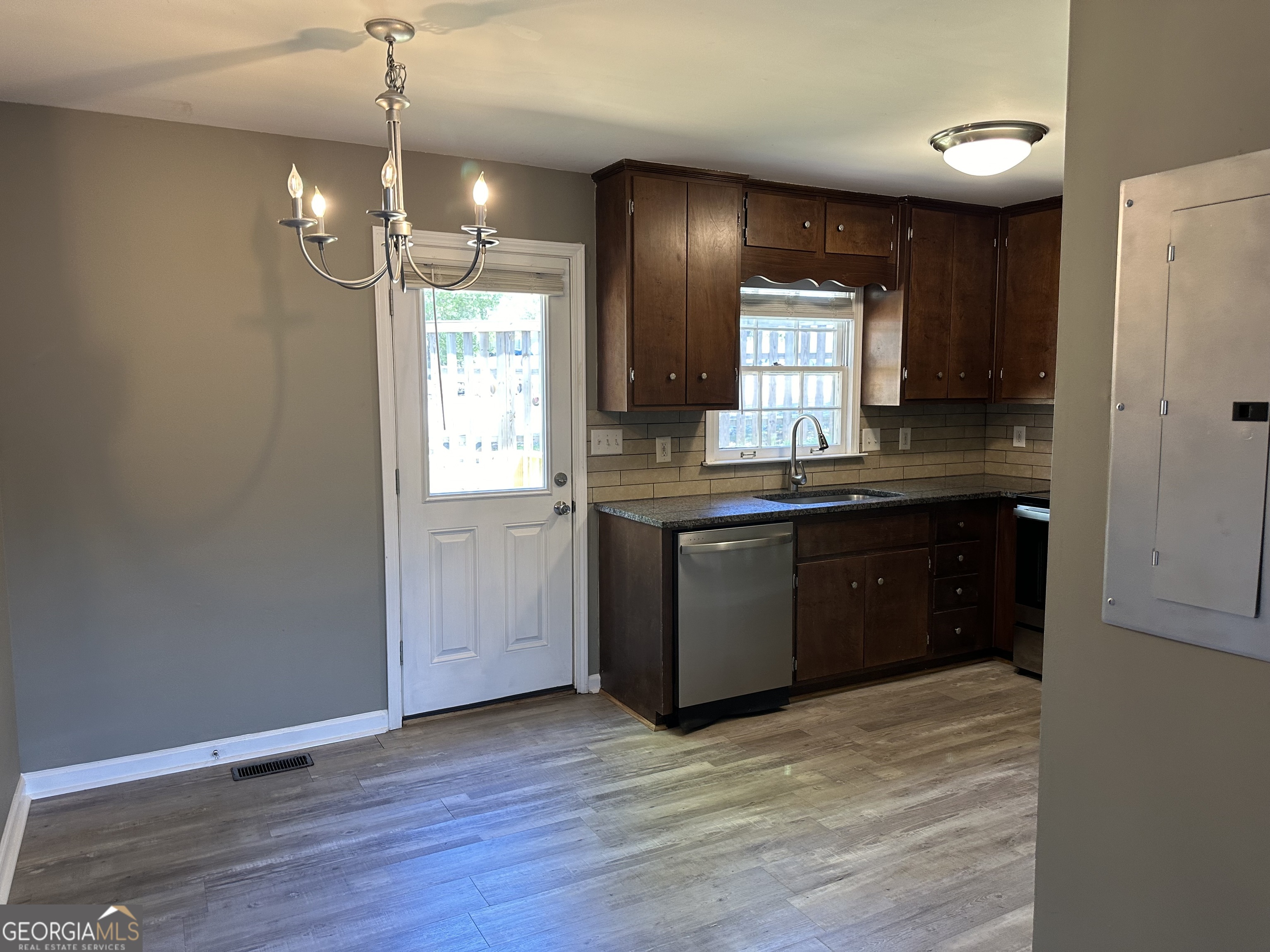 205 Maret Street Hartwell, GA 30643 - Photo 21 of 38 a kitchen with kitchen island granite countertop wooden cabinets and white appliances