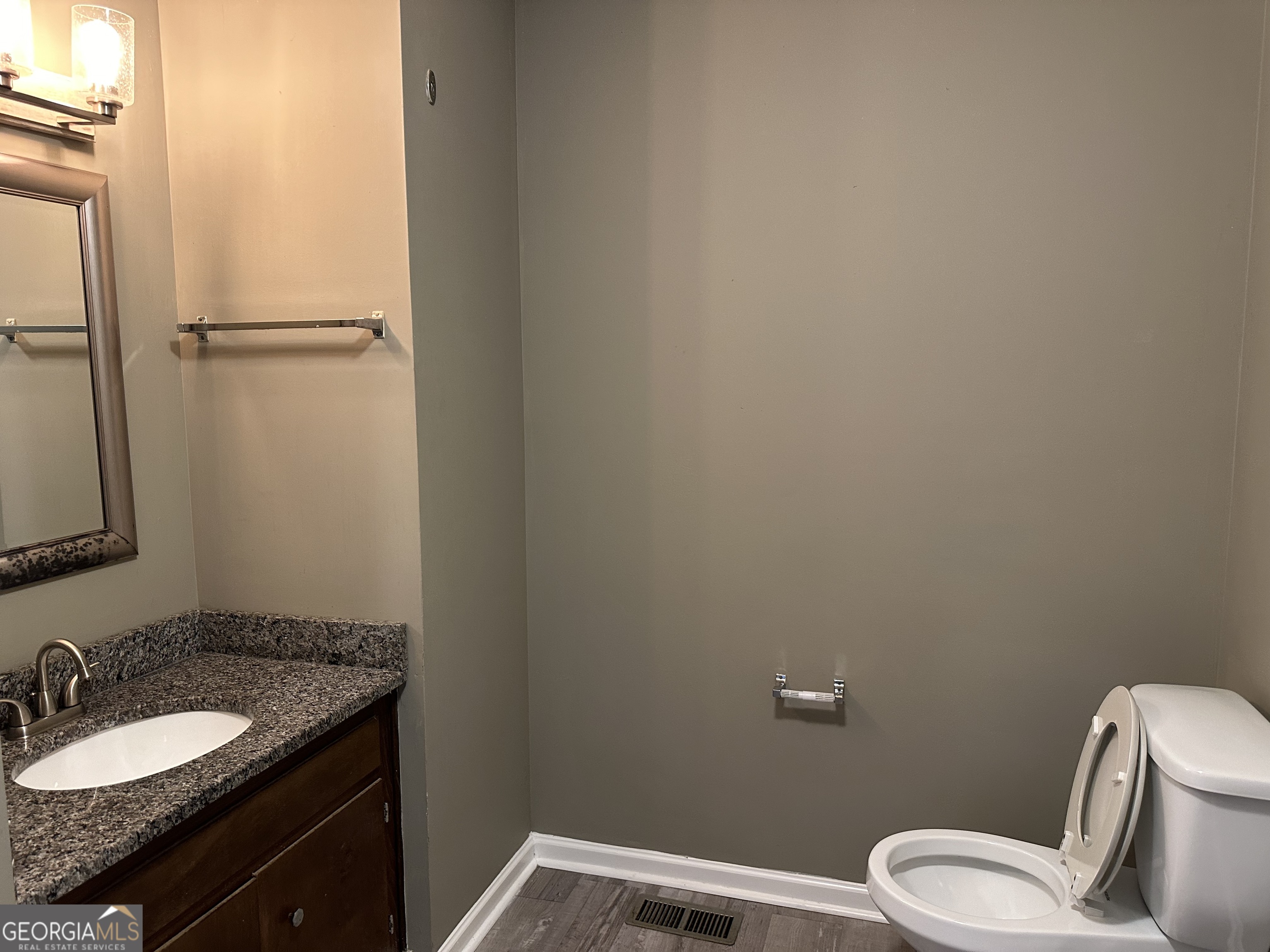 205 Maret Street Hartwell, GA 30643 - Photo 23 of 38 a bathroom with a granite countertop sink toilet and a mirror