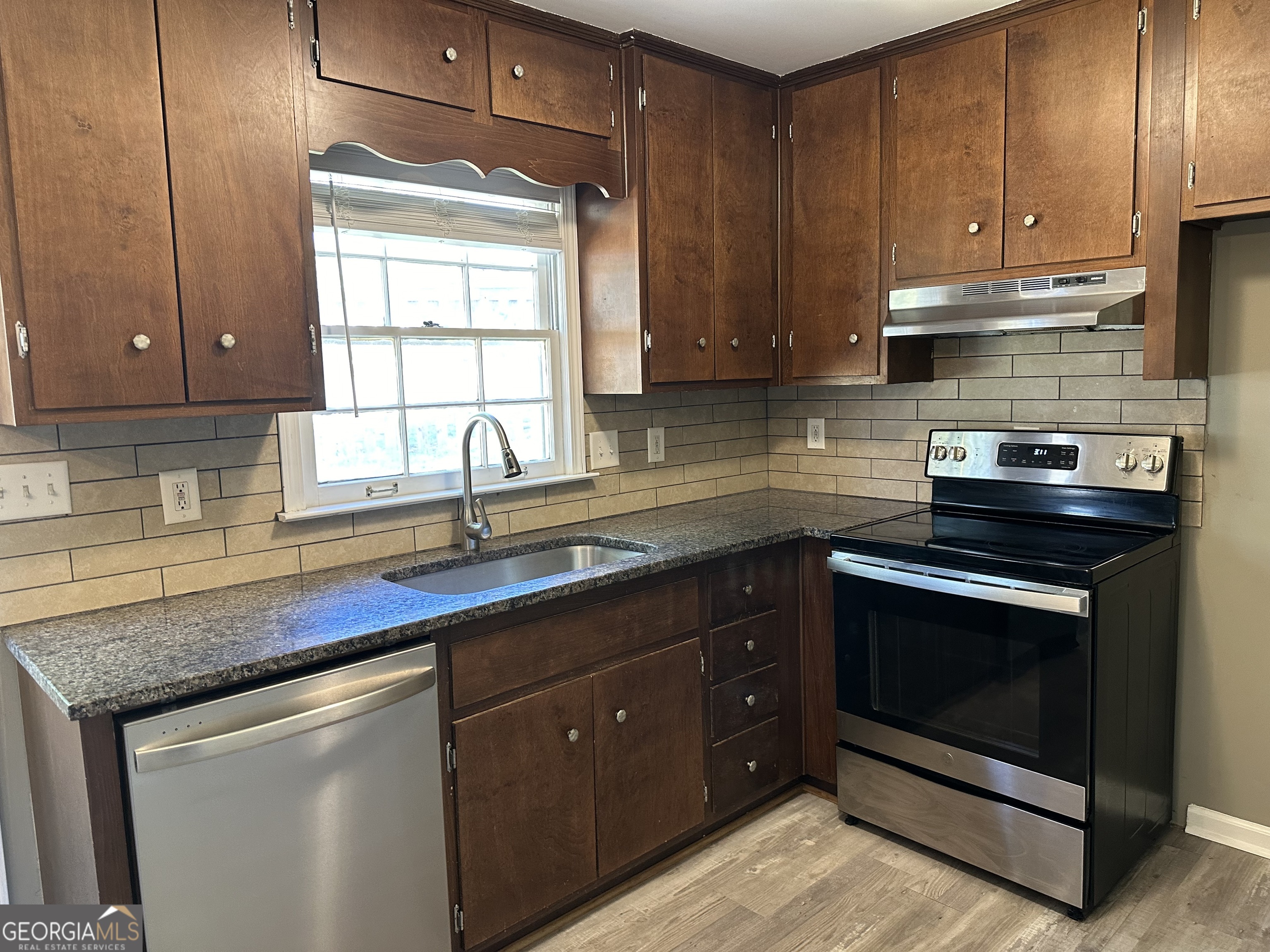 205 Maret Street Hartwell, GA 30643 - Photo 25 of 38 a kitchen with stainless steel appliances granite countertop a sink stove and cabinets