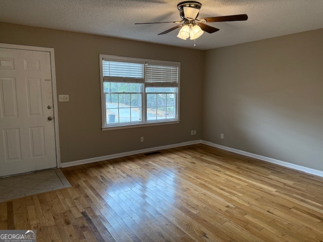 205 Maret Street Hartwell, GA 30643 - Photo 32 of 38 an empty room with wooden floor chandelier fan and windows