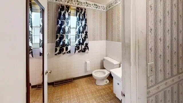 a bathroom with a toilet and a shower curtain