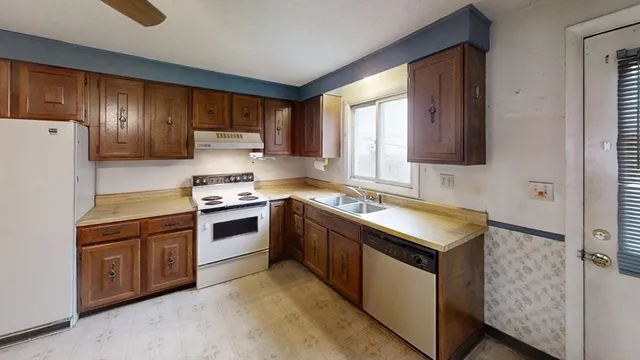 a kitchen with stainless steel appliances granite countertop a stove a sink and a refrigerator