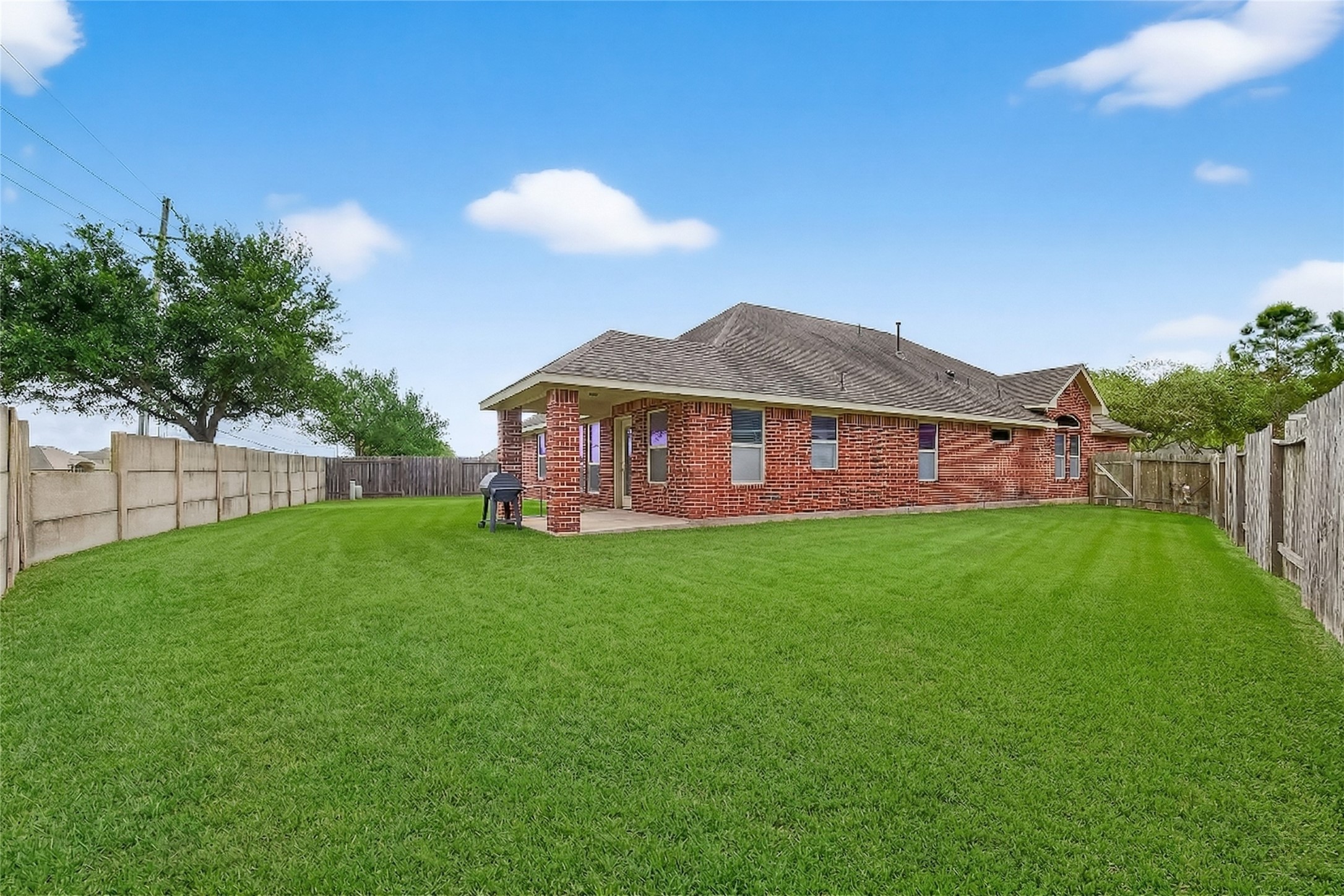 13415 Star Creek Lane Rosharon, TX 77583 - Photo 33 of 46 a view of a yard with a large tree and a table and chair in the back