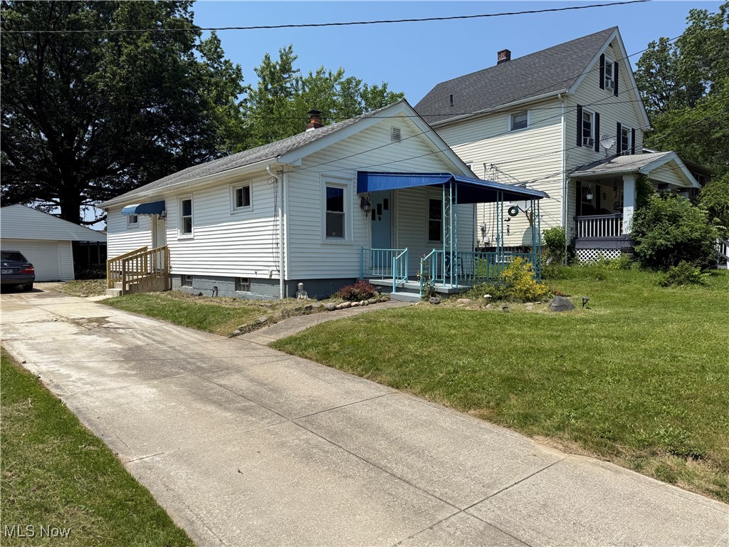 6350 Meadowbrook Road Garfield Heights, OH 44125 - Photo 2 of 28 View of front of home featuring a front lawn, an outdoor structure, covered porch, and a chimney