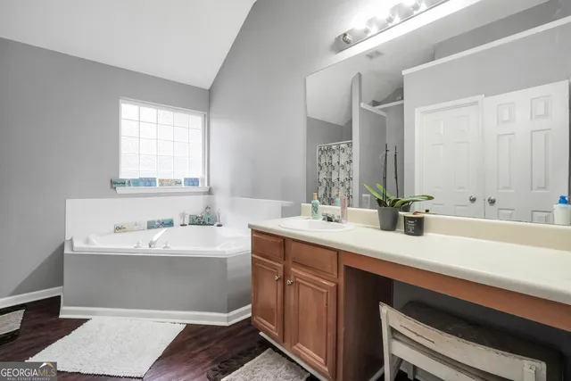 a bathroom with a double vanity sink mirror and bathtub