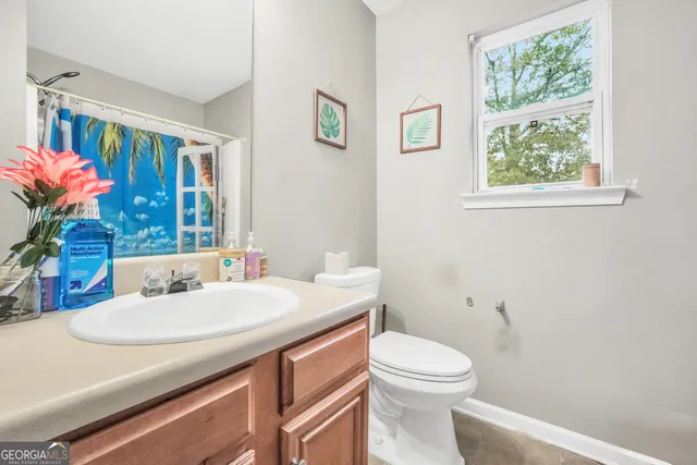 a bathroom with a sink a toilet and a window