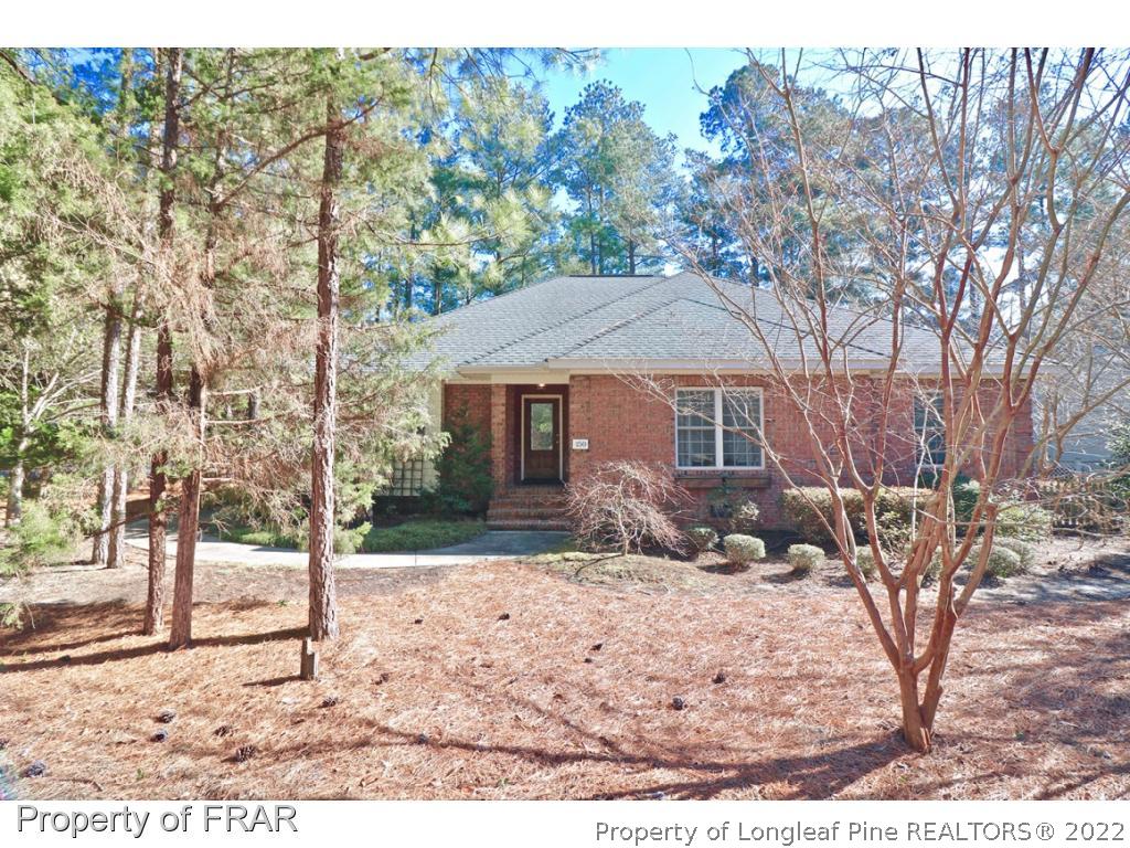150 Lost Tree Road Pinehurst, NC 28374 - Photo 1 of 36 a front view of a house with a yard covered with snow in outdoor space