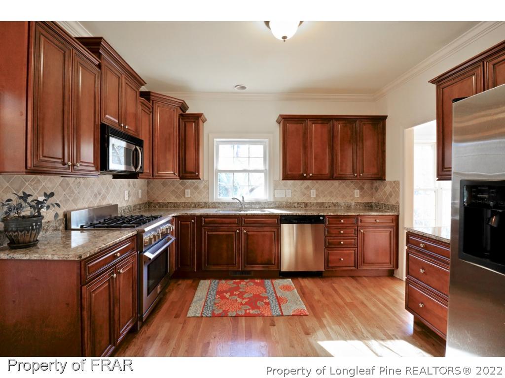 150 Lost Tree Road Pinehurst, NC 28374 - Photo 14 of 36 a kitchen with stainless steel appliances granite countertop wooden cabinets stove top oven and granite counter top