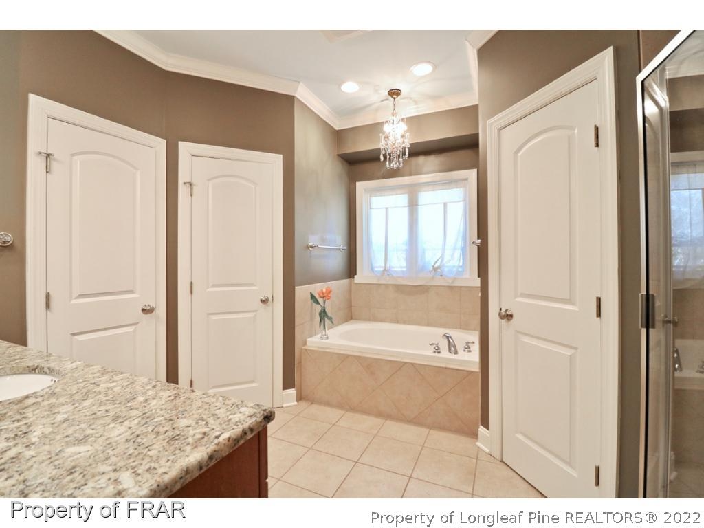 150 Lost Tree Road Pinehurst, NC 28374 - Photo 22 of 36 a bathroom with a tub shower and a sink