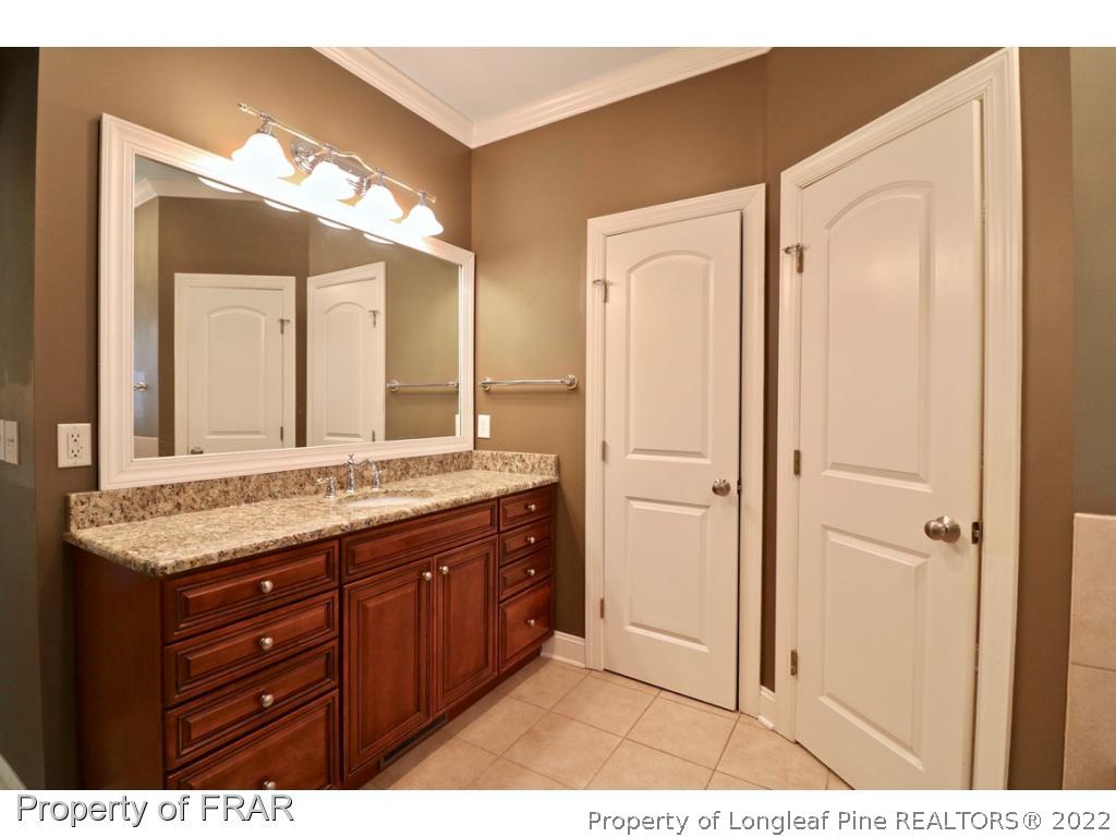 150 Lost Tree Road Pinehurst, NC 28374 - Photo 25 of 36 a bathroom with a granite countertop sink a mirror and a shower