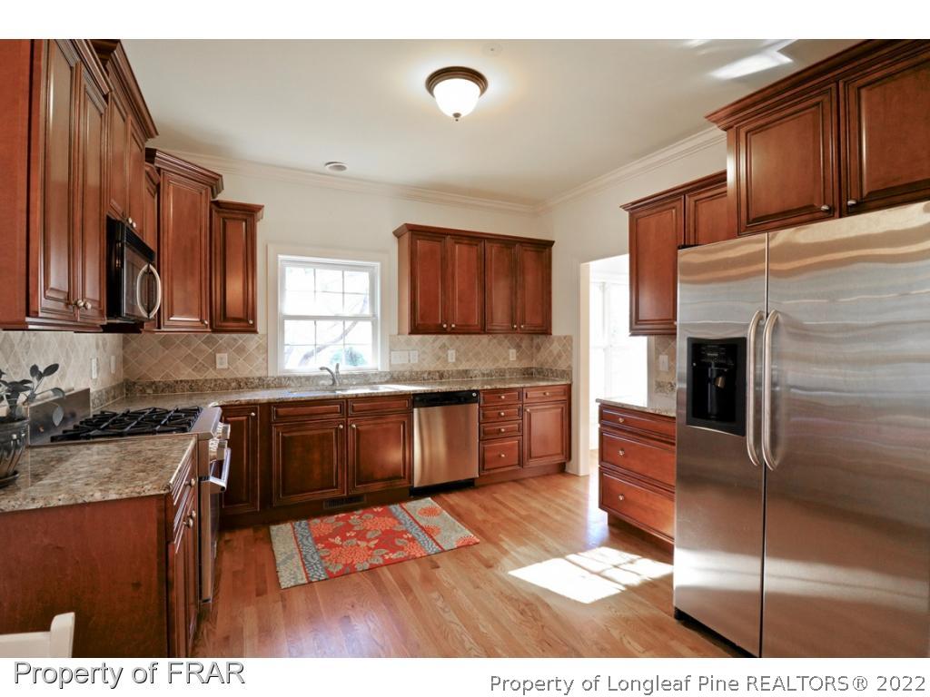 150 Lost Tree Road Pinehurst, NC 28374 - Photo 4 of 36 a kitchen with granite countertop a sink cabinets and stainless steel appliances