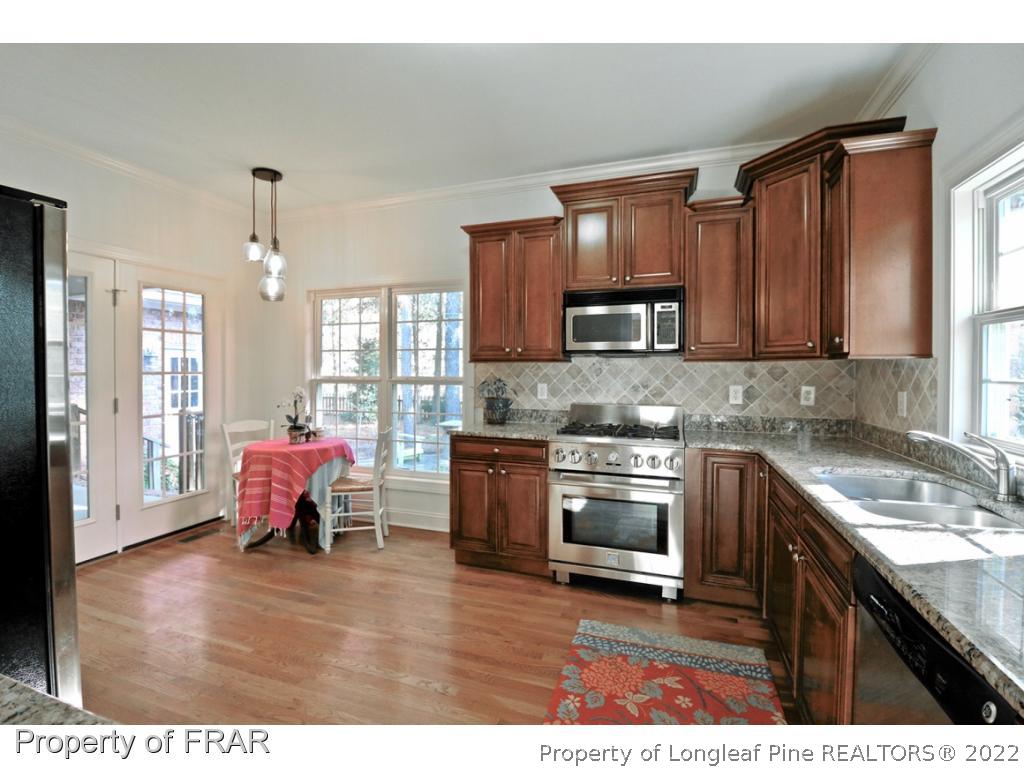 150 Lost Tree Road Pinehurst, NC 28374 - Photo 6 of 36 a kitchen with granite countertop wooden floors sink and cabinets