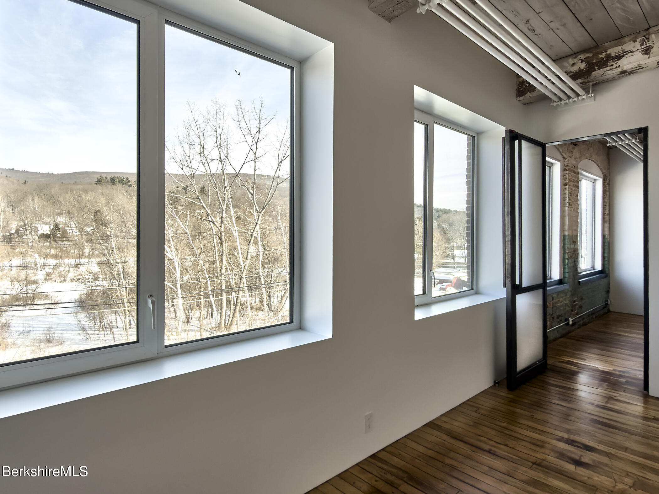 520 State Road, Unit 309 North Adams, MA 01247 - Photo 16 of 19 a view of an empty room with wooden floor and a window