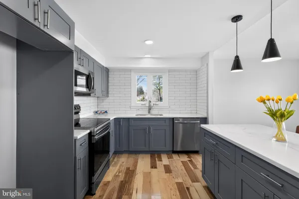 a kitchen with stainless steel appliances granite countertop sink stove and cabinets