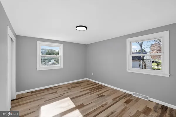a view of a bedroom with wooden floor and window