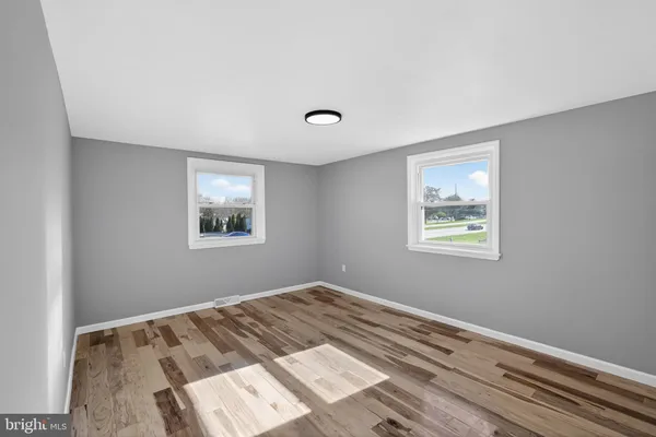 a view of a room with wooden floor and windows