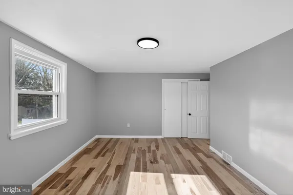 a view of an empty room with window and closet area