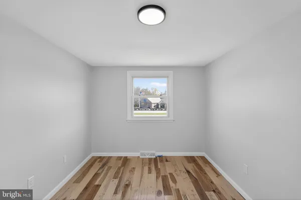 a view of a room with wooden floor and window
