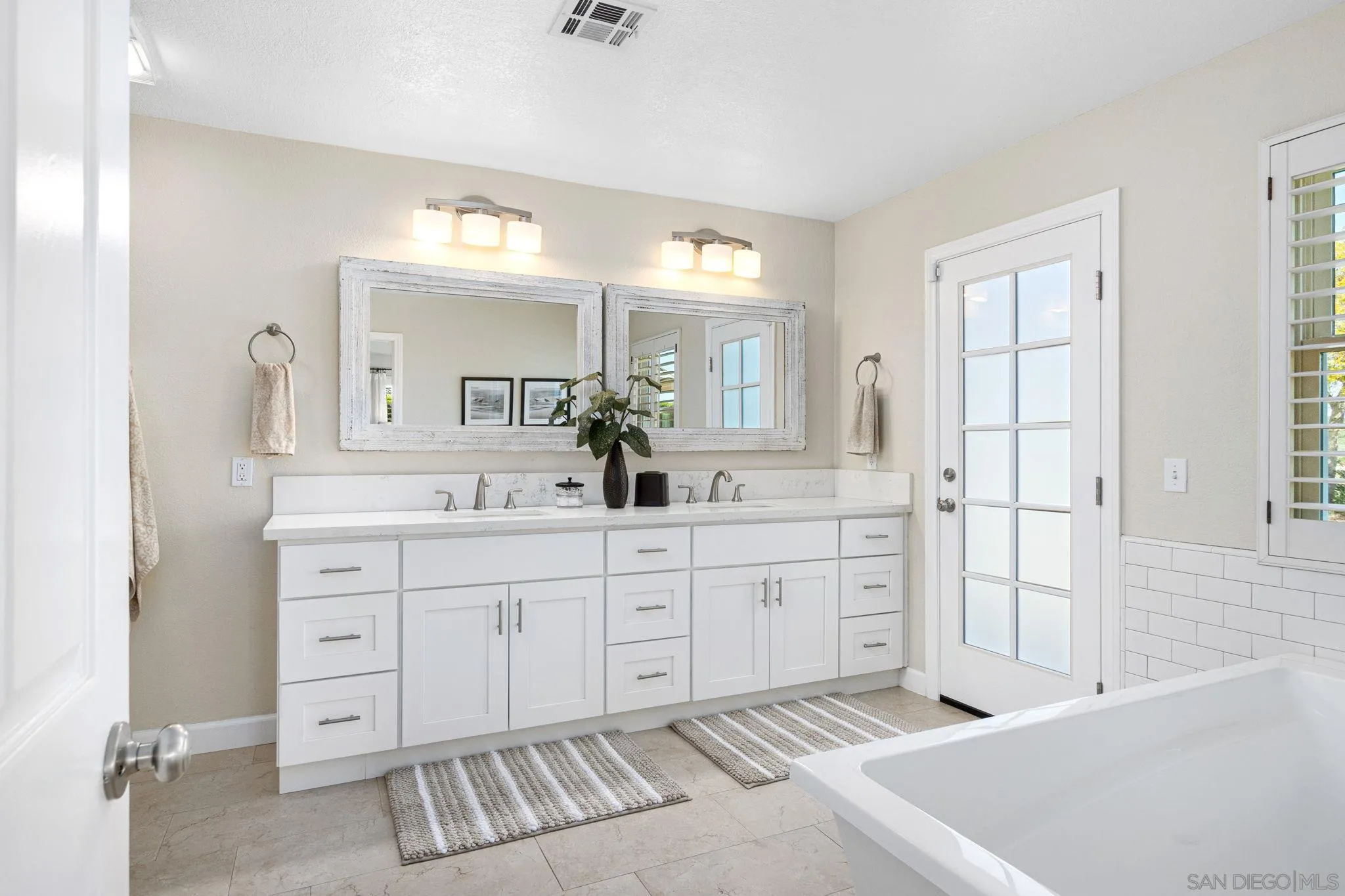 360 Futurity Lane Fallbrook, CA 92028 - Photo 21 of 58 a spacious bathroom with a double vanity sink a mirror a bathtub and next to a window