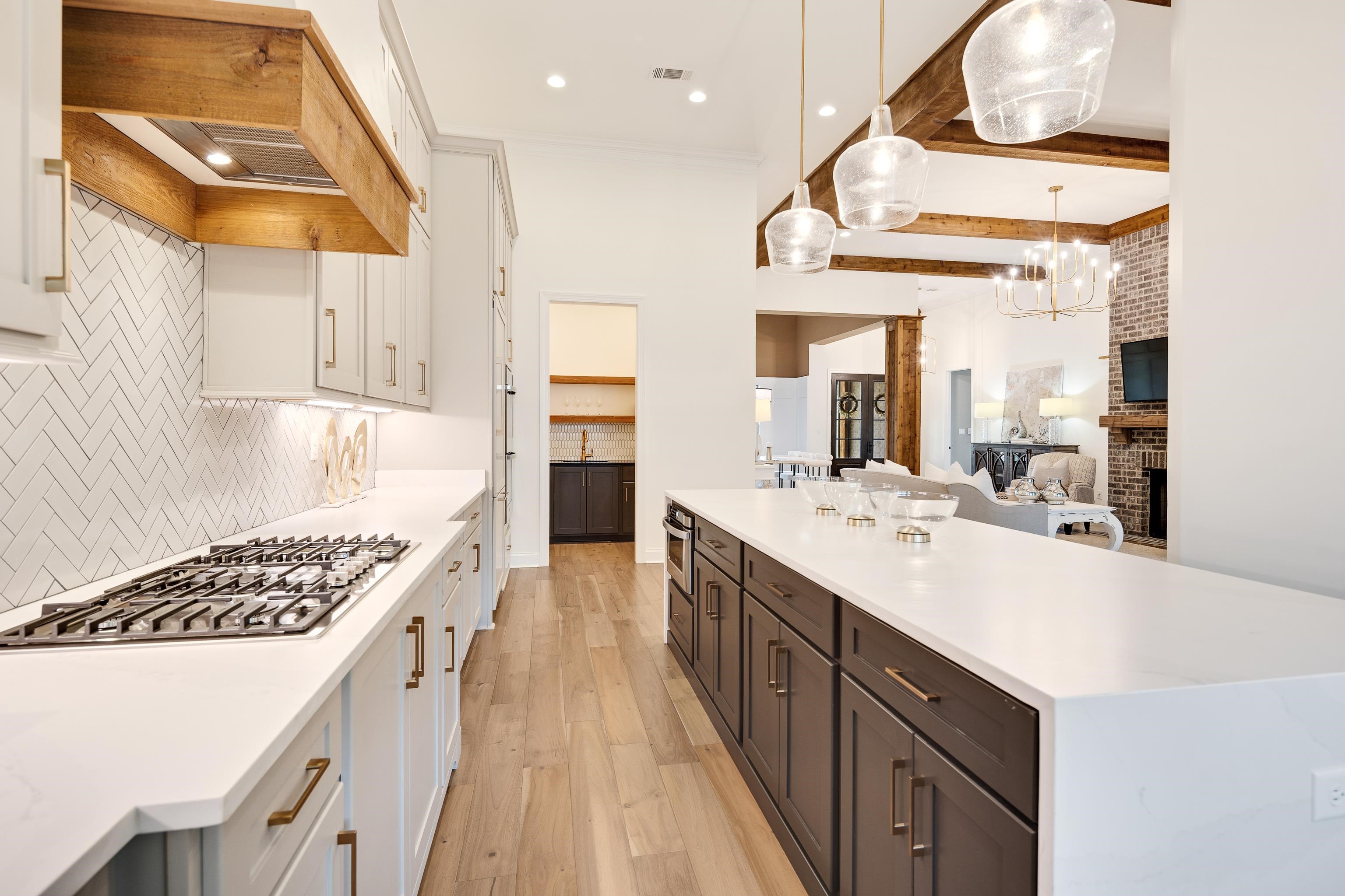 237 Beckham Drive Collierville, TN 38017 - Photo 11 of 40 Kitchen featuring light wood-style flooring, white cabinetry, stainless steel appliances, custom exhaust hood, and light countertops