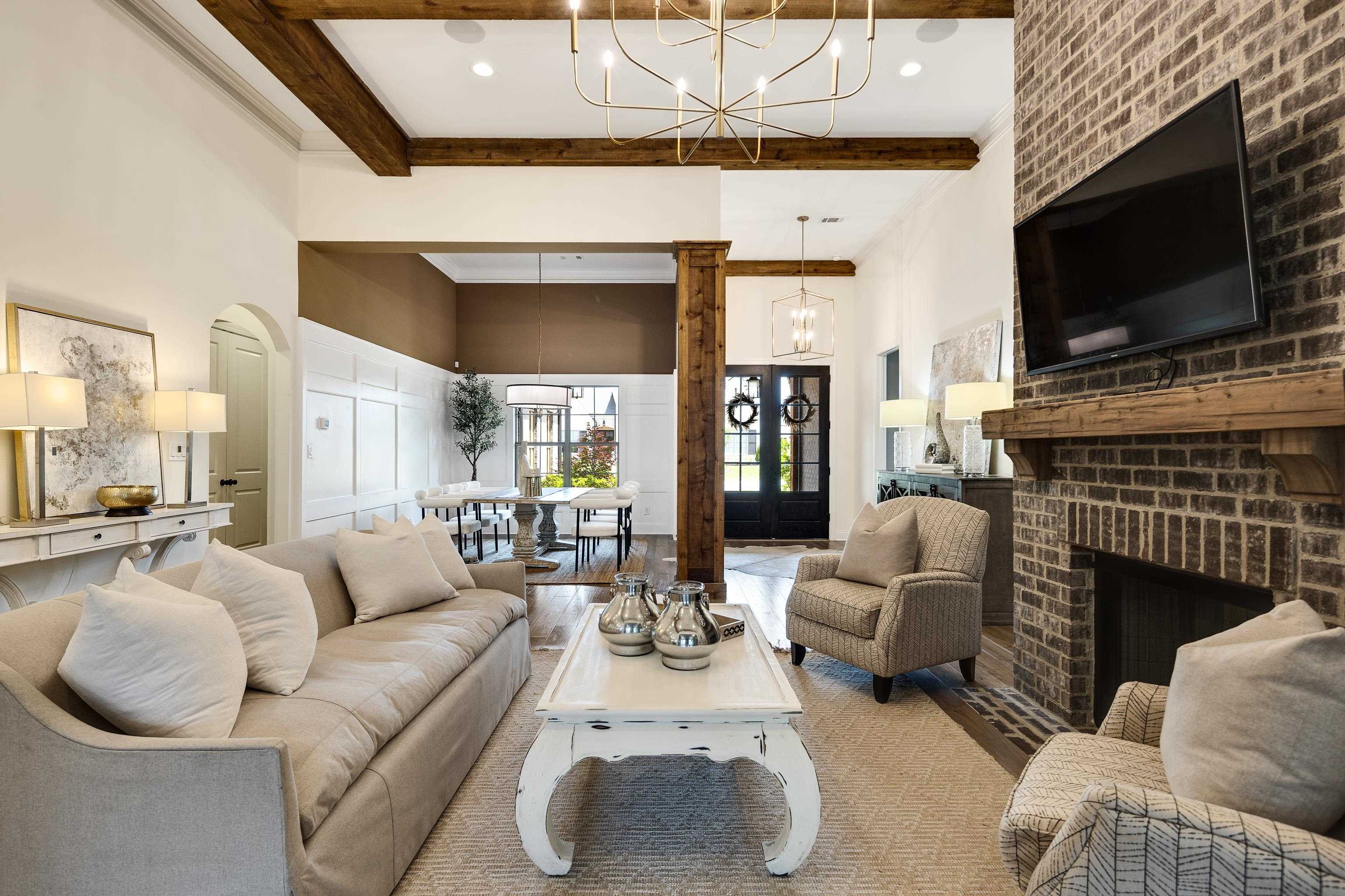 237 Beckham Drive Collierville, TN 38017 - Photo 15 of 40 Living area featuring a high ceiling, a chandelier, beamed ceiling, and a fireplace