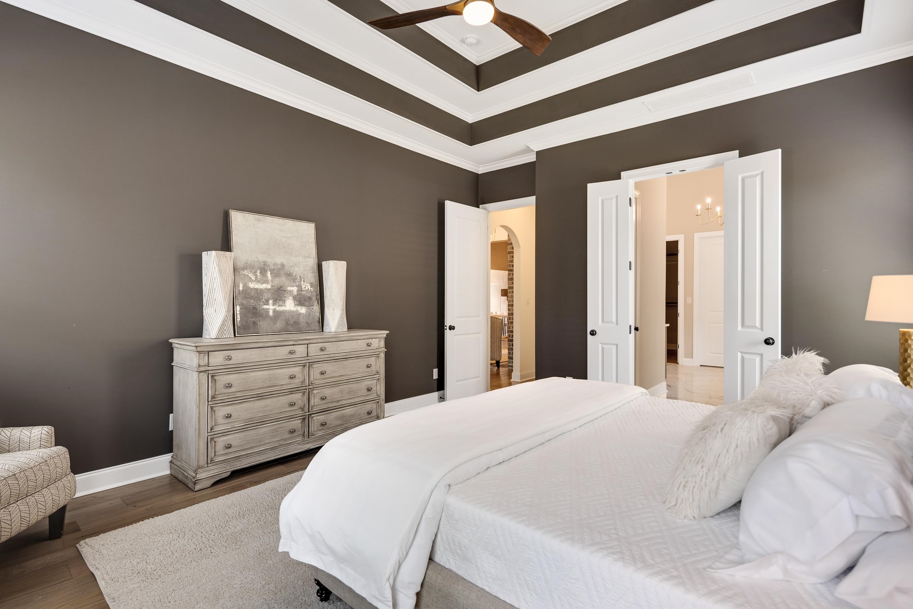 237 Beckham Drive Collierville, TN 38017 - Photo 17 of 40 Bedroom featuring crown molding, dark wood finished floors, arched walkways, baseboards, and ceiling fan