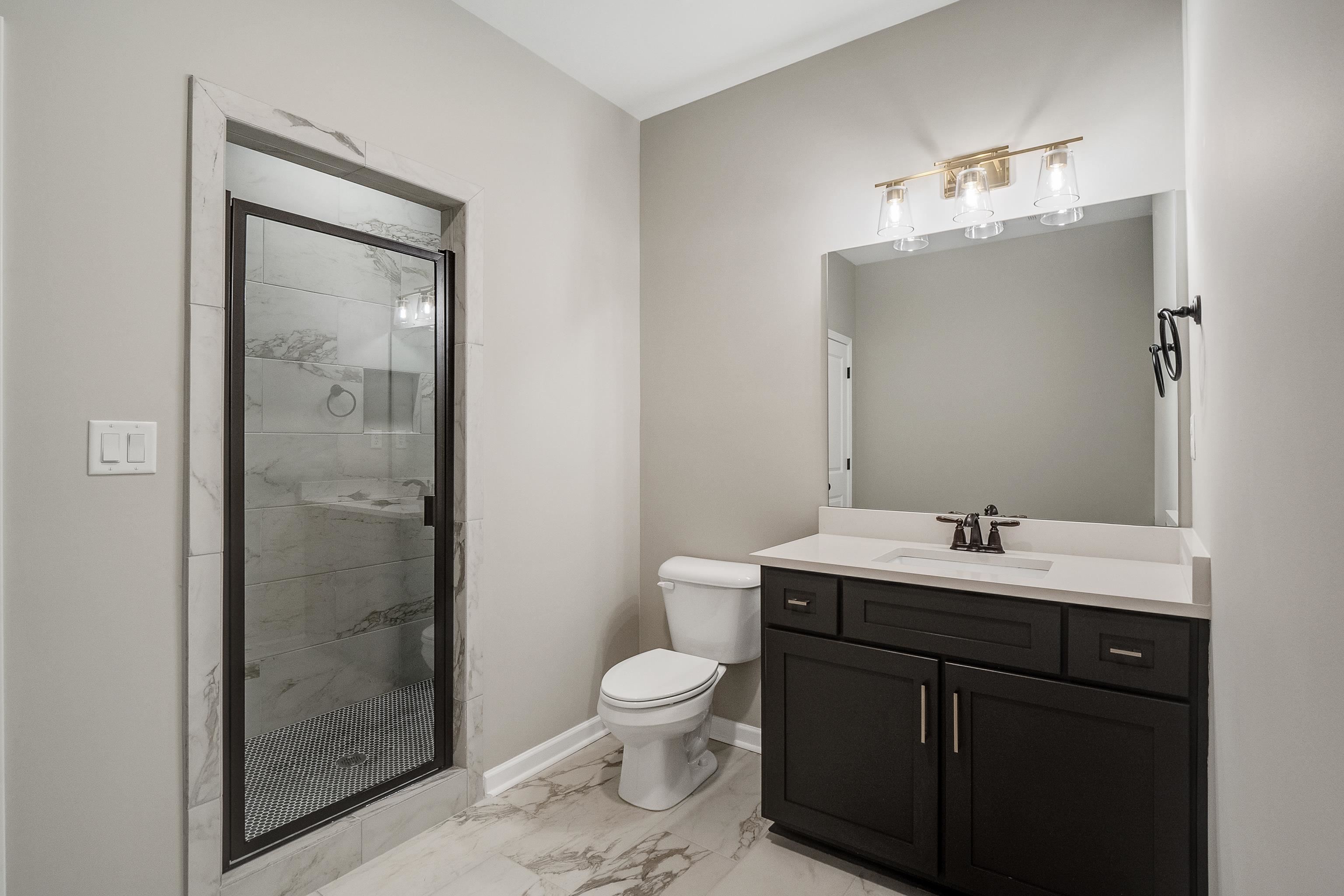 237 Beckham Drive Collierville, TN 38017 - Photo 33 of 40 Full bathroom featuring toilet, vanity, baseboards, marble finish floor, and a stall shower
