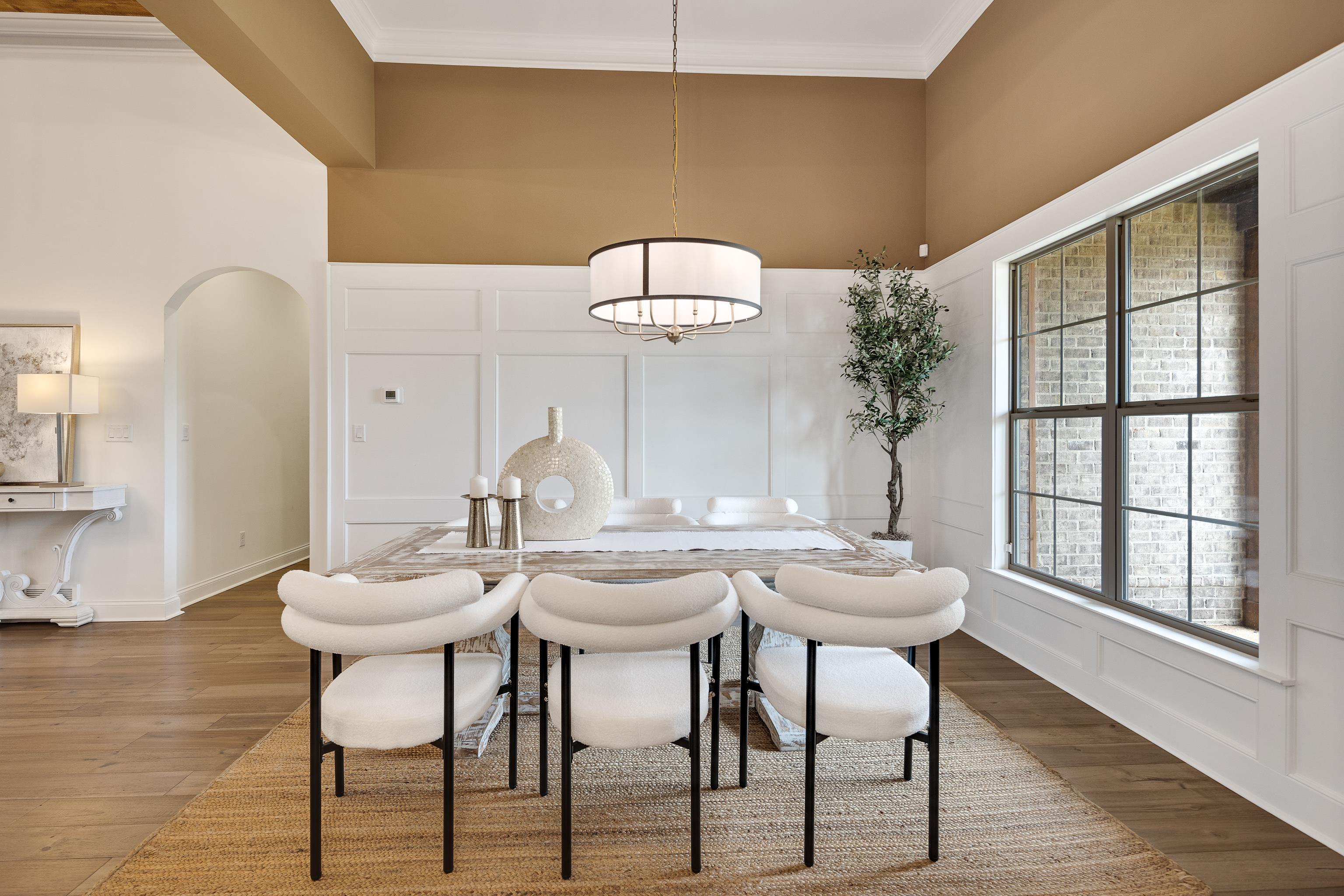 237 Beckham Drive Collierville, TN 38017 - Photo 4 of 40 Dining area with a decorative wall, wood finished floors, arched walkways, crown molding, and a high ceiling