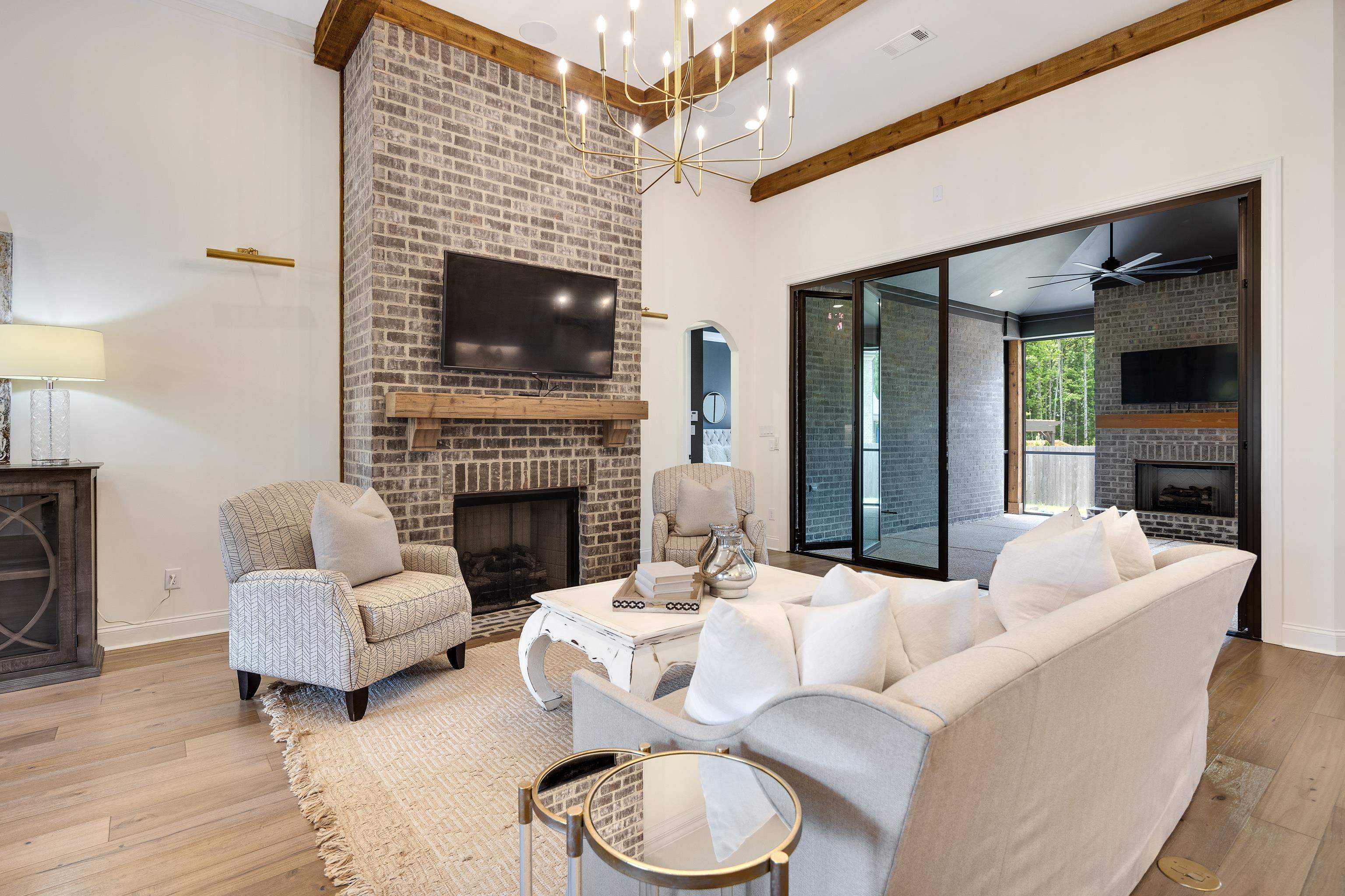 237 Beckham Drive Collierville, TN 38017 - Photo 6 of 40 Living area with a fireplace, wood finished floors, beamed ceiling, a chandelier, and baseboards