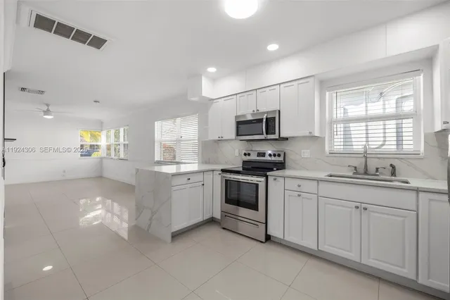 a kitchen with white cabinets and white appliances