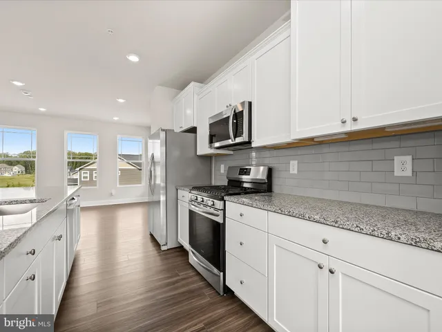 a kitchen with stainless steel appliances granite countertop a stove and a sink