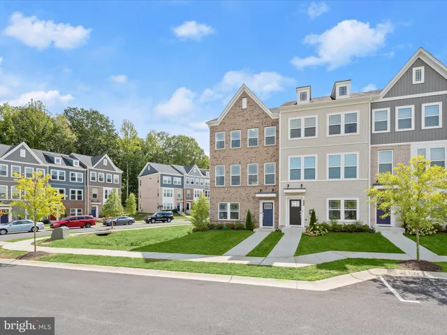 a front view of residential houses with yard and green space