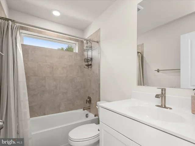a bathroom with a sink a mirror toilet and bathtub