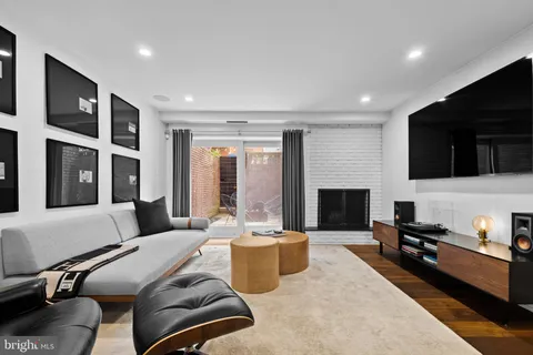 a living room with a piano and wooden floor