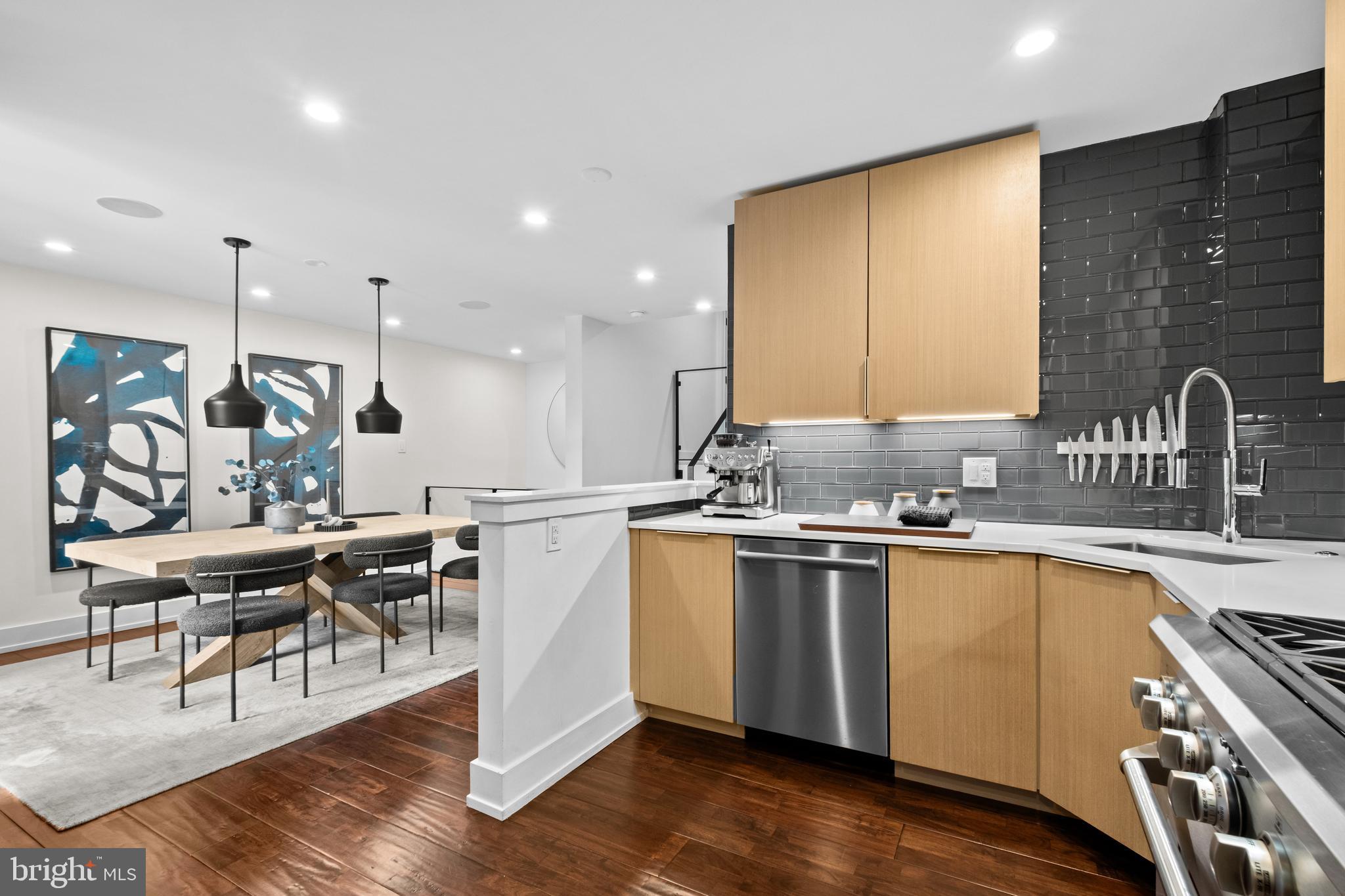 502 Delancey Street, Unit A Philadelphia, PA 19106 - Photo 5 of 32 a kitchen with stainless steel appliances granite countertop a stove a sink dishwasher a dining table and chairs with wooden floor
