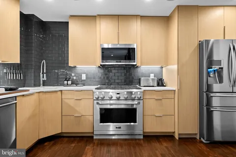 a kitchen with stainless steel appliances a stove microwave and sink